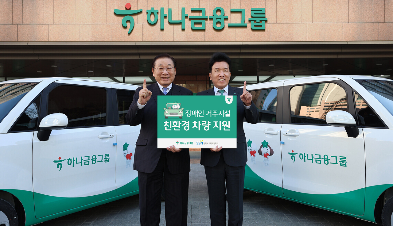 Hana Financial Group Chair and CEO Ham Young-joo (right) poses with Korea Council on Social Welfare Chair Kim Soung-yee during a vehicle donation ceremony at the group’s headquarters in Myeong-dong, central Seoul, Monday. Hana donated eco-friendly electric and compact vehicles to 10 residential facilities for people with disabilities to help enhance mobility rights and strengthen welfare infrastructure for those with limited transportation access. “Mobility is the first step toward connecting with society,” Ham said. “We hope this support enables residents to enjoy everyday life without inconvenience.” (Hana Financial Group)