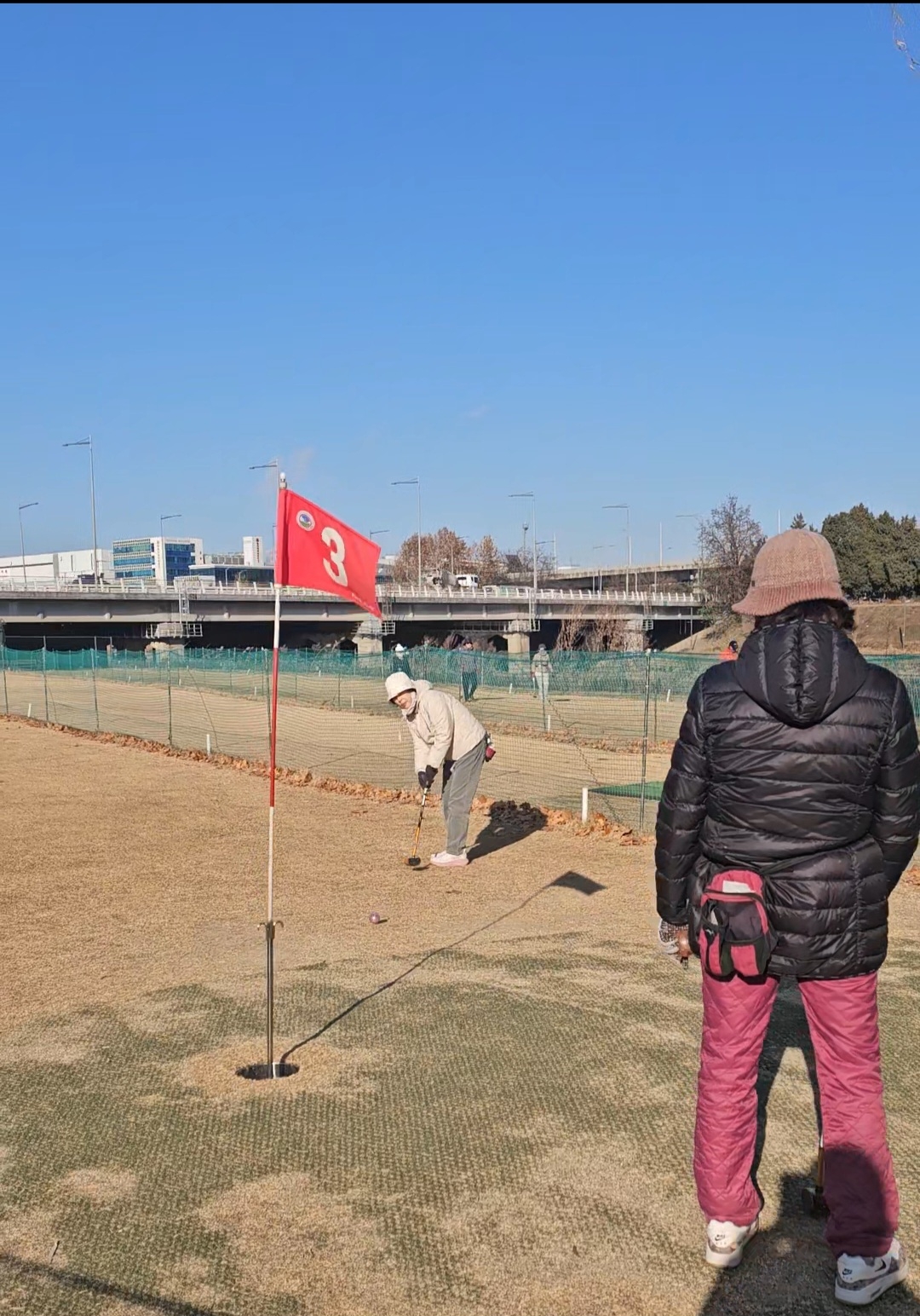 A woman hits a ball toward a flagstick. (Choi Jae-hee / The Korea Herald)