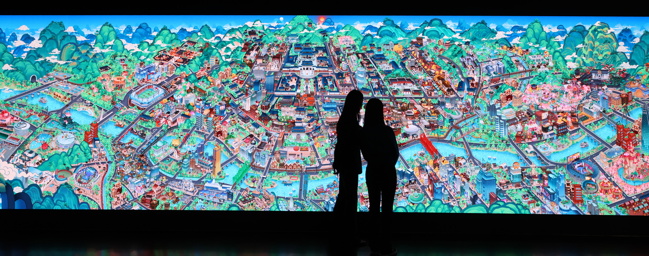 Staff members take a look at media artwork during a press preview of the special show “CookieRun: In Search of Korea's Lost Heritage,” held at Dondeokjeon Hall in Deoksugung, Seoul, Monday. (Yonhap)