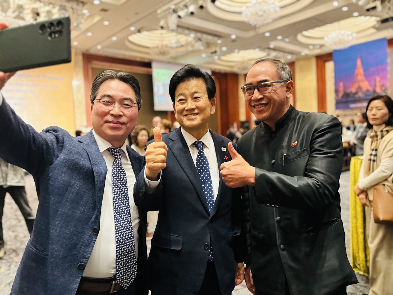 Thai Ambassador to Korea Tanee Sangrat (right) and South Korea’s Minister of Unification Chung Dong-young (center) pose for a selfie before Thai National Day event at Lotte Hotel, Seoul, on Dec. 3. (Sanjay Kumar/ The Korea Herald)