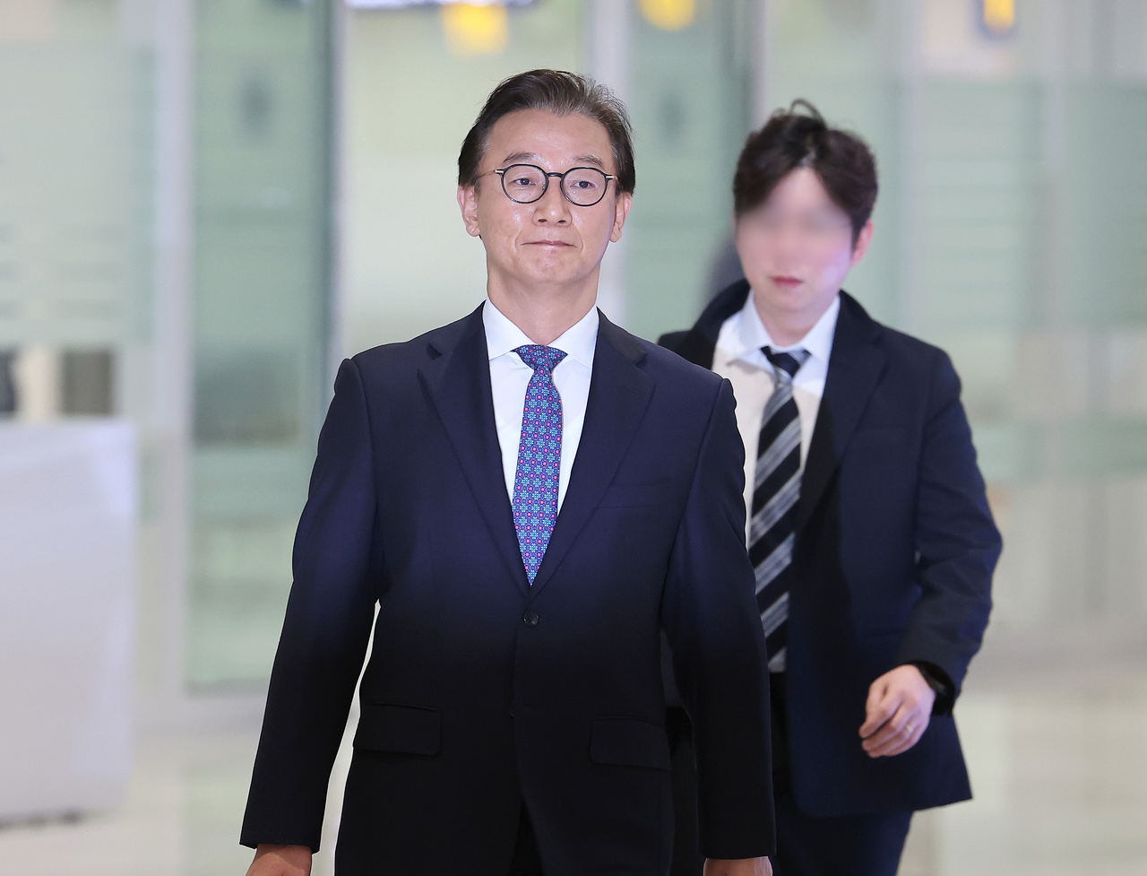 Oceans Minister Chun Jae-soo (L) arrives at Incheon International Airport, west of Seoul, returning from a UN meeting in New York, on Thursday, amid allegations that he received illegal funds from the Unification Church. (Yonhap)
