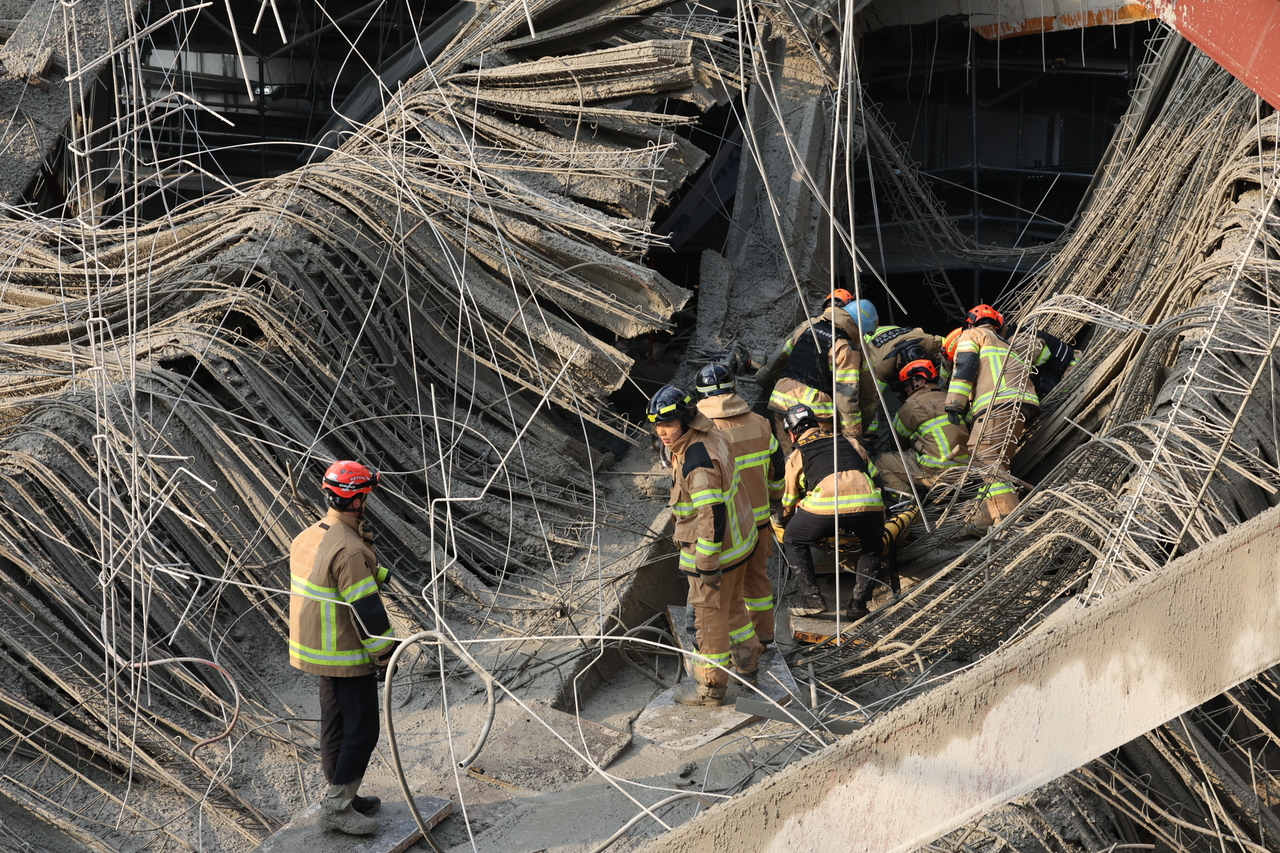 Firefighters work to rescue people trapped in debris after a collapse at the construction site of the Gwangju Metropolitan Library in Chipyeong-dong, Seo-gu, Gwangju, Thursday. (Yonhap)