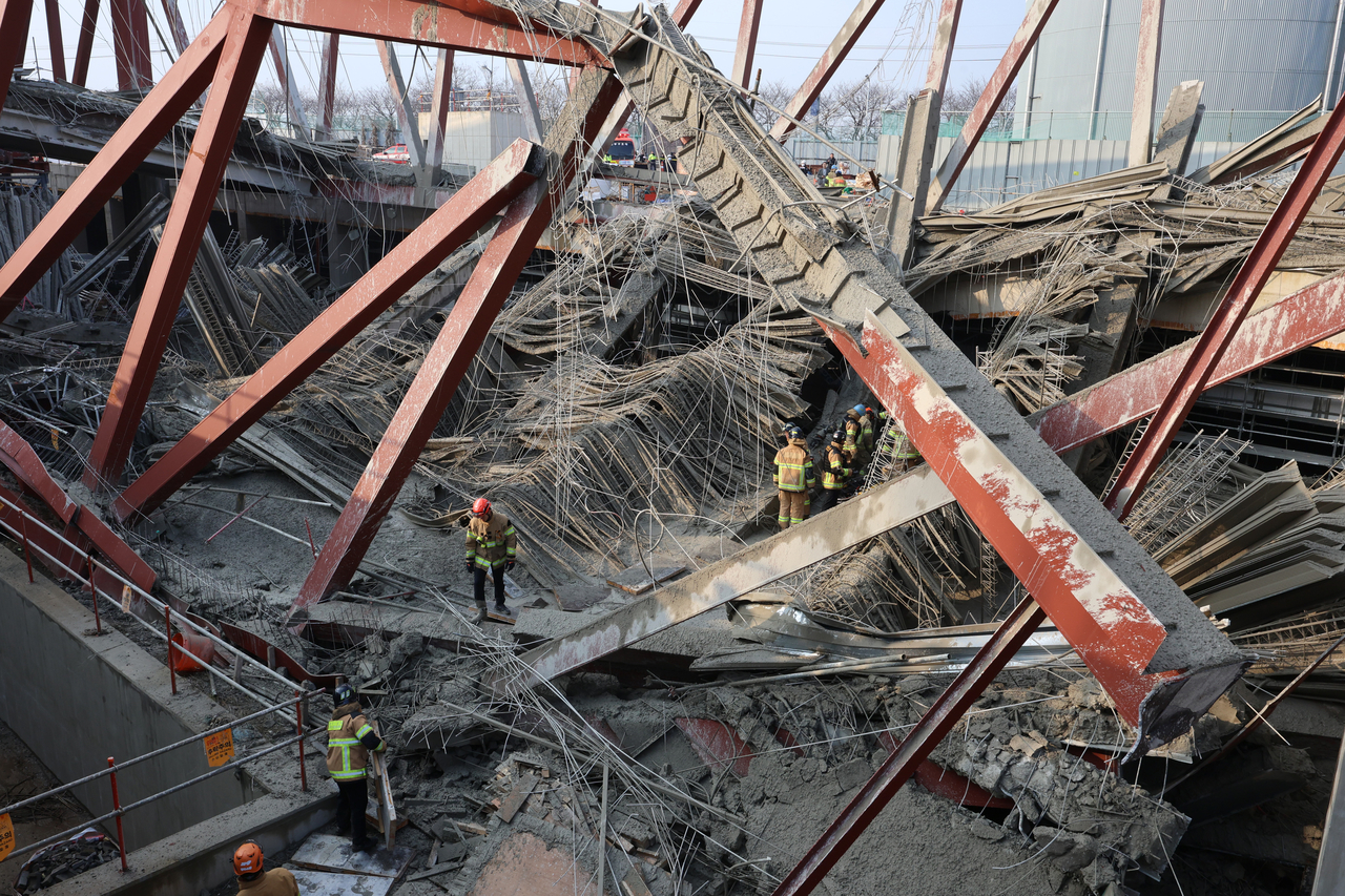 Rescue officials search for three trapped workers at a library construction site in Gwangju, Thursday. (Yonhap)