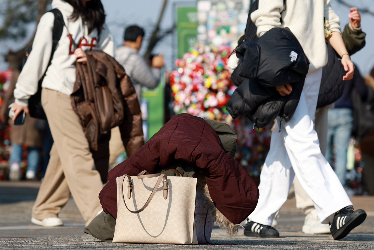 Citizens visiting Namsan in Seoul on Dec. 7 walk while carrying their outerwear. (Yonhap)