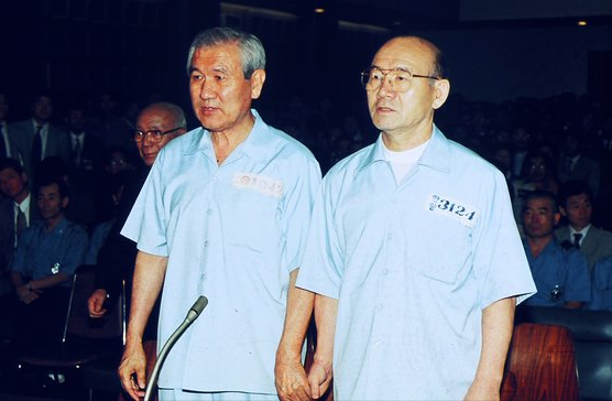 Former Presidents Chun Doo-hwan (right) and Roh Tae-woo hold hands at the Seoul Central District Court on Aug. 26, 1996, as the judges verify their identity. (Yonhap)