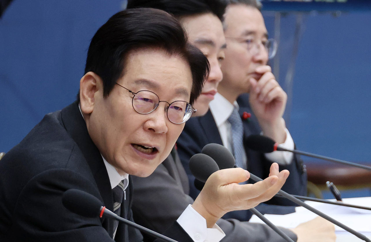 President Lee Jae Myung (left) speaks during the year-end policy briefing of the Ministry of Science and ICT and the Personal Information Protection Commission in Sejong on Friday. (Yonhap)