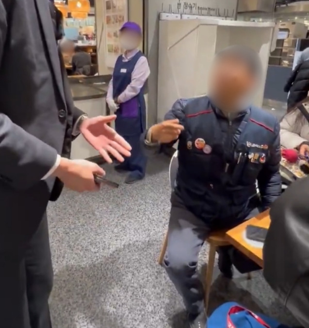 In this screenshot from a video, department store security asks a union worker to leave or remove his union vest on Dec. 10. (Captured image from X)