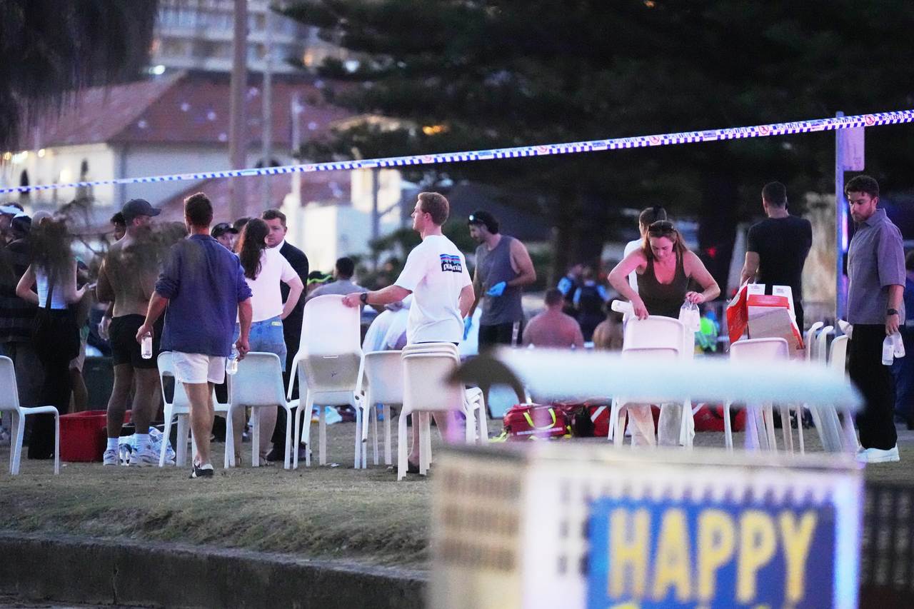 People and emergency workers gather at location where a holiday event was taking place and then a reported shooting at Bondi Beach in Sydney, Sunday. (AP -Yonhap)