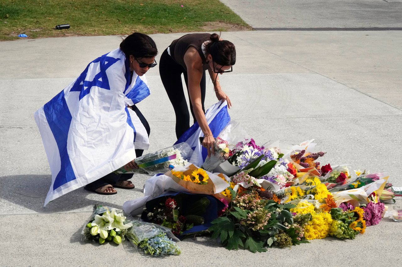 Women place flowers at a memorial outside Bondi Pavilion at Sydney's Bondi Beach, Monday, a day after a shooting. (AP-Yonhap)