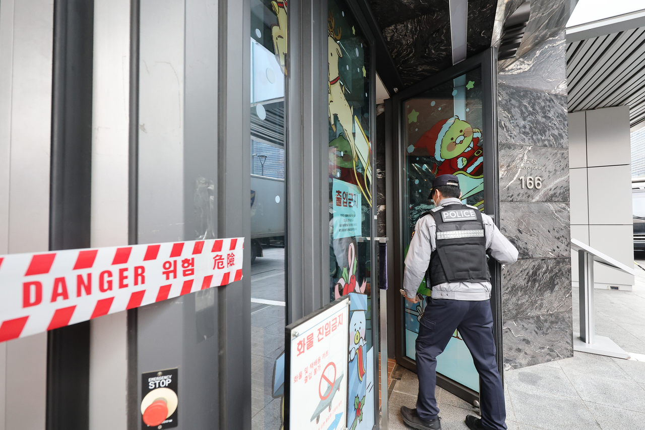 A police officer enters the Kakao headquarters in Seongnam, Gyeonggi Province, on Monday, as police and the military search the building following a bomb threat made earlier that day. (Yonhap)