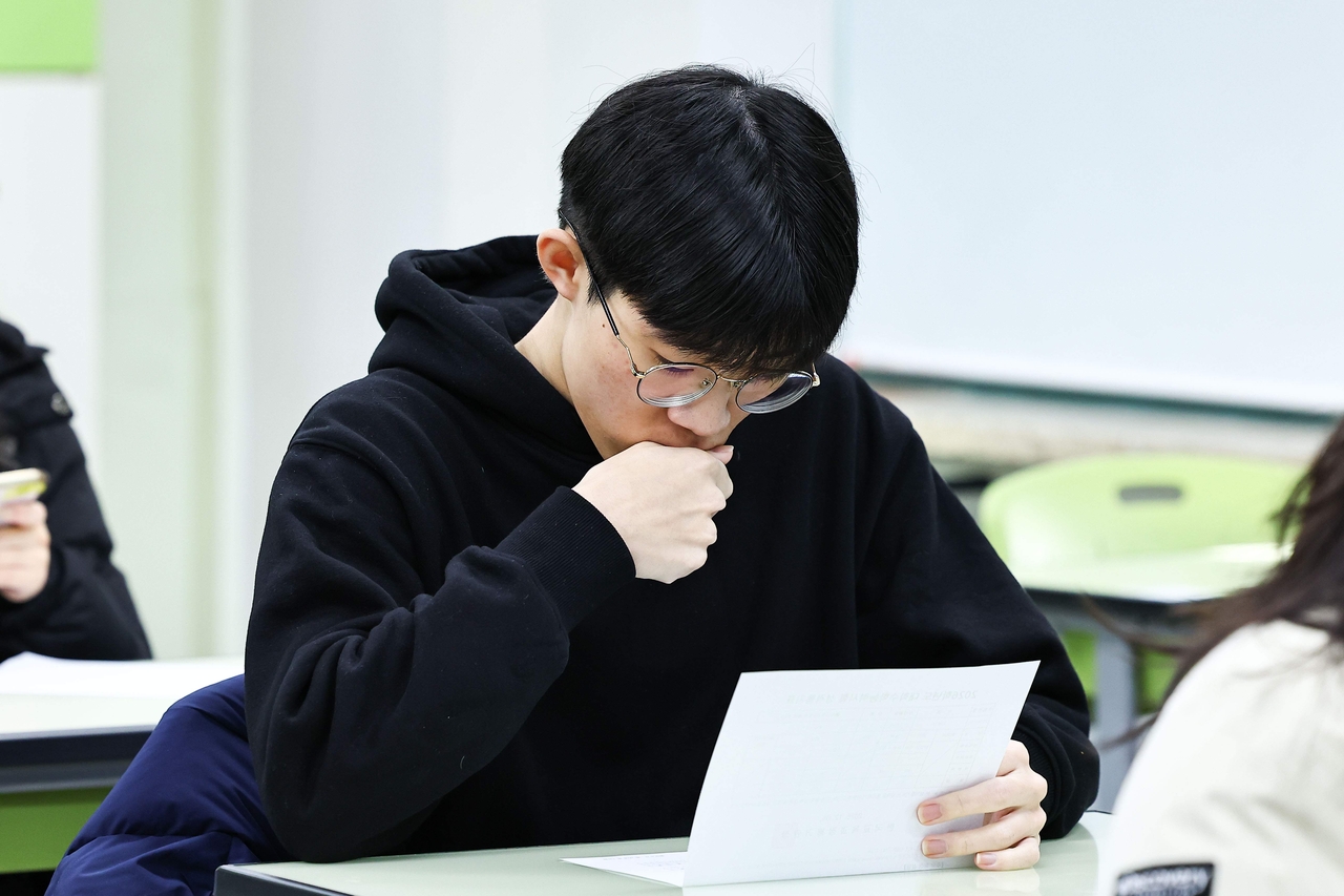 A high school senior in Seoul reviews his Suneung scores on Dec. 5. (Yonhap)