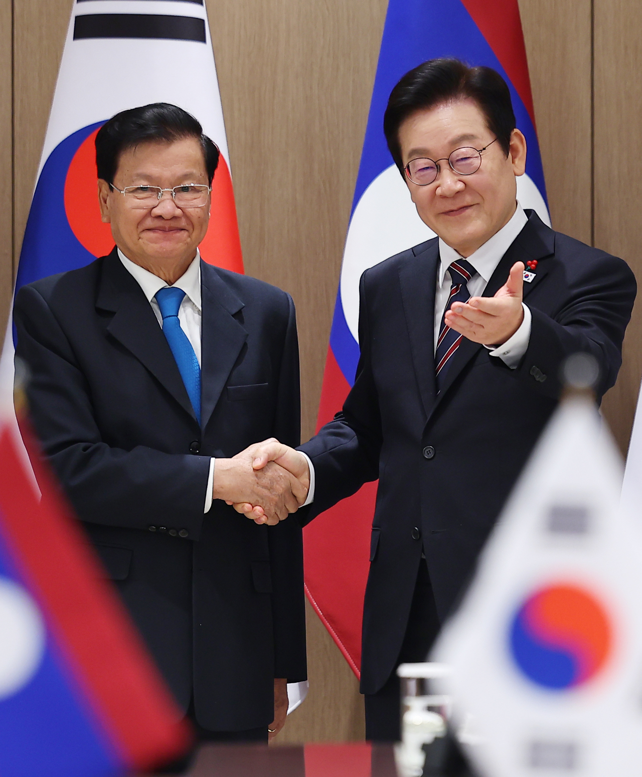 President Lee Jae Myung (right) and Laotian President Thongloun Sisoulith shake hands during a summit at the presidential office in Seoul on Monday. (Yonhap)