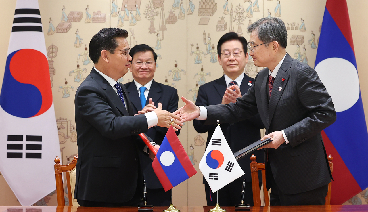 Cho Hyun (right), South Korea's minister of foreign affairs, attends the signing ceremony with Xaysana Khotphouthone (left), chief of the Supreme People's Prosecutor Office of Laos, as the two countries signed an extradition treaty on Monday. (Yonhap)