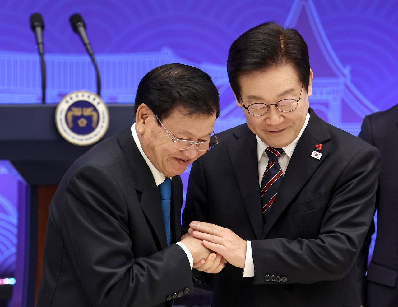 President Lee Jae Myung (right) and Laotian President Thongloun Sisoulith shake hands during an official lunch hosted by Lee in his office in Seoul on Monday. (Pool photo via Yonhap)