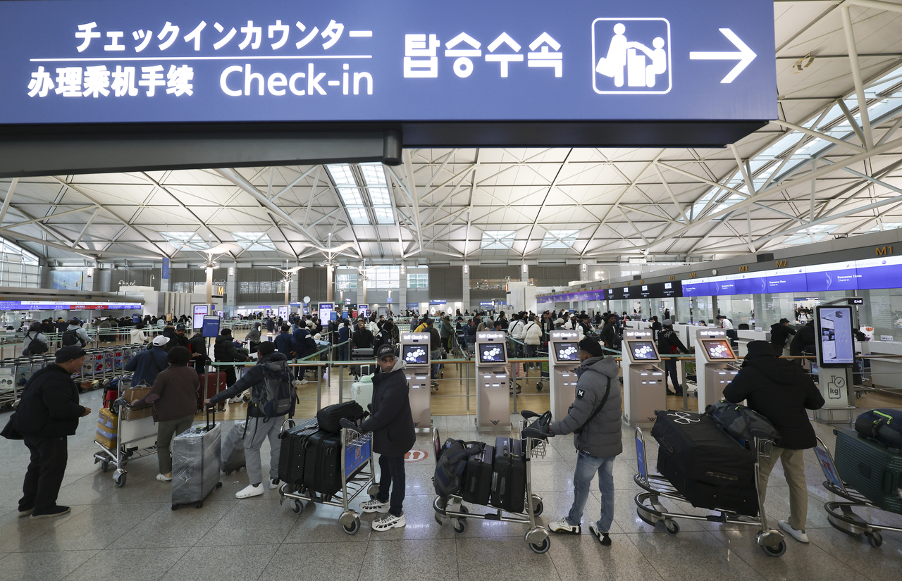 Passengers wait in line for departure procedures at Terminal 1 of Incheon Airport on Dec. 3. (Newsis)
