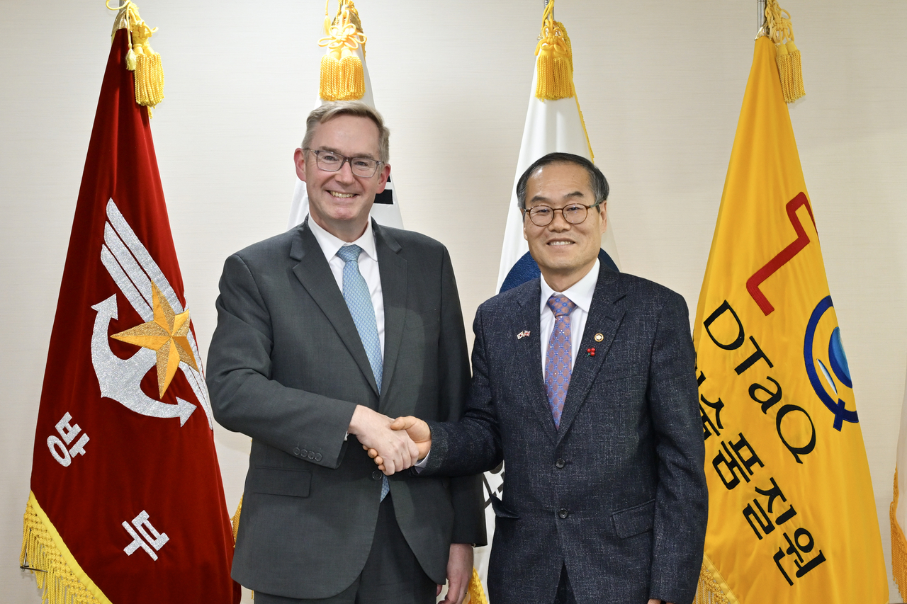 Defense Acquisition Program Administration (DAPA) Minister Lee Yong-cheol (right) and British Ambassador Colin Crooks shake hands during their meeting in Gwacheon, south of Seoul, on Wednesday in this photo provided by DAPA. (Yonhap)