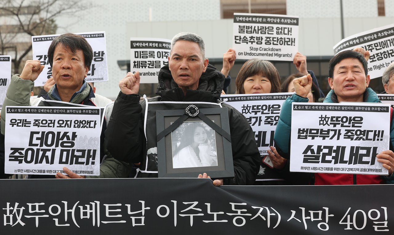 Vu Van Sung (center), father of Tu Ahn, holds a portrait of his daughter during a protest in front of the presidential office in central Seoul on Dec. 9. (Yonhap)