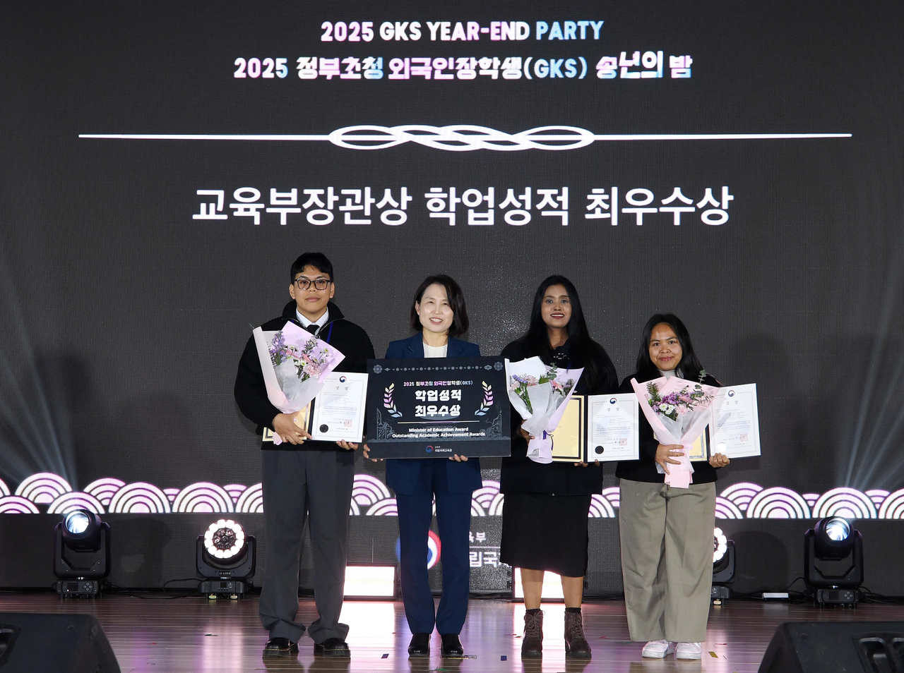 Three international students, Castillo Mark John (first right), Ranbhise Jyotsna Suresh (third right) and Lestari Windy Ayu (fourth right) pose for a picture, Tuesday, after receiving an award from the Ministry of Education. (Ministry of Education)