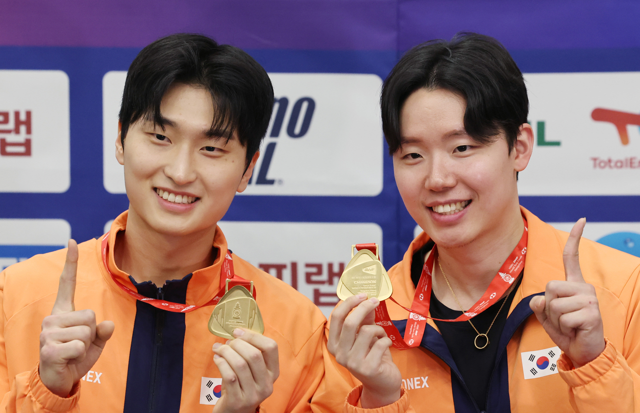 South Korean men's doubles badminton players Kim Won-ho (L) and Seo Seung-jae pose with their gold medals from the men's doubles event at the Badminton World Federation World Tour Finals after a media scrum at Incheon International Airport, west of Seoul, on Monday. (Yonhap)
