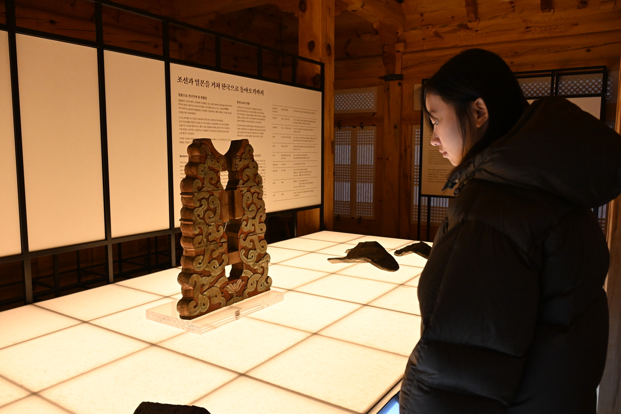 A visitor examines the daegong, an architectural bracket that supports the center of the roof, during the opening ceremony on Tuesday. (Korea Heritage Service)