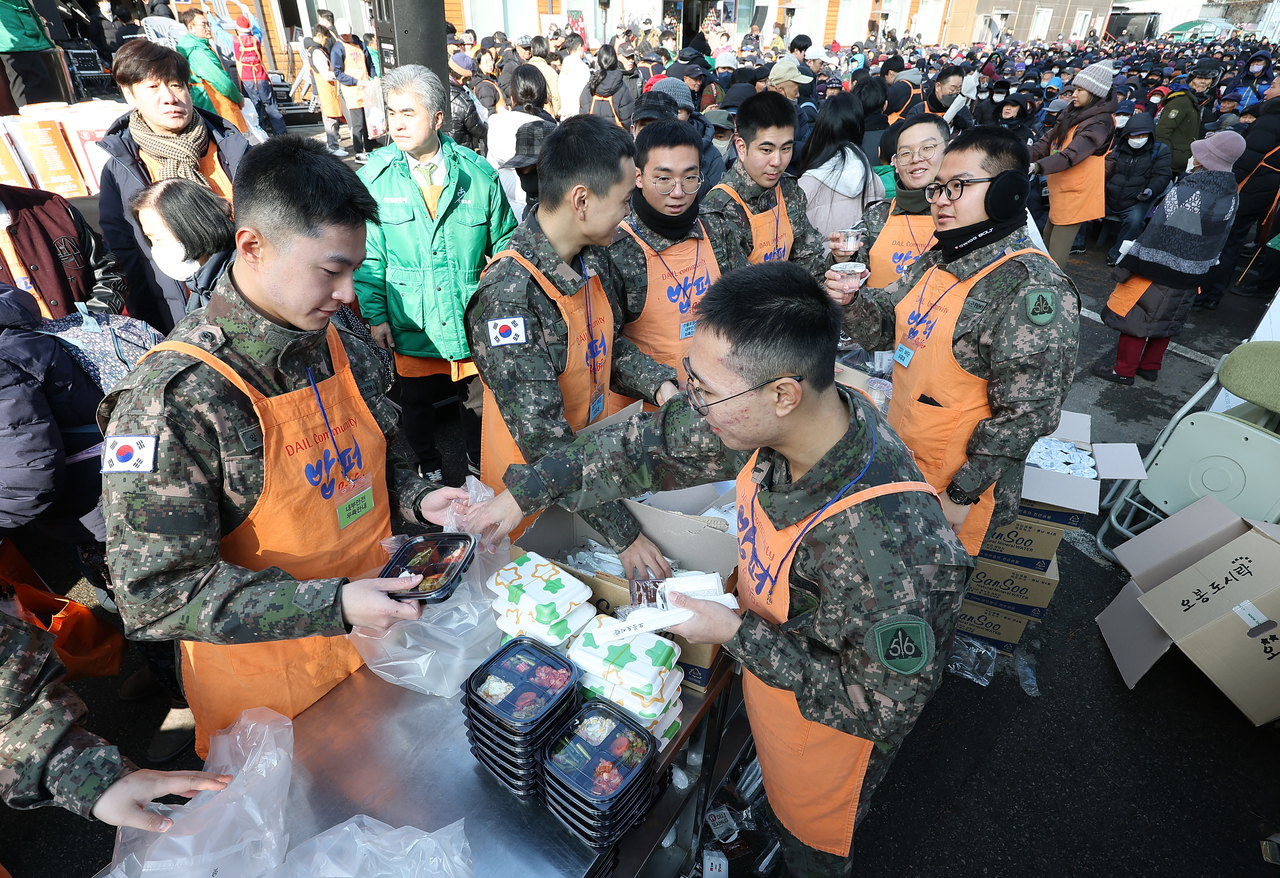 Soldier volunteers package food during a giveaway event held by the Babfor Sharing Movement in Dongdaemun-gu, Seoul, on Wednesday. (Yonhap)