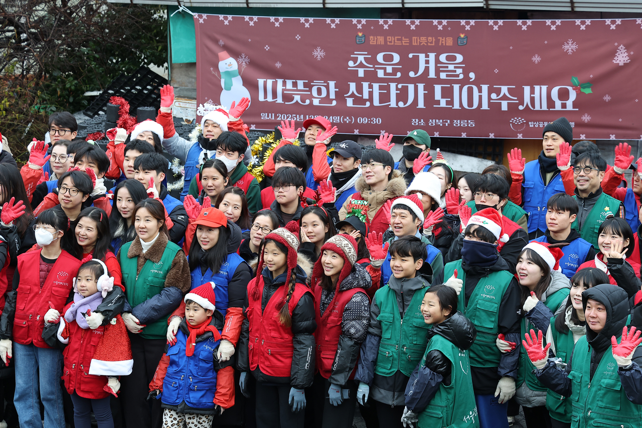 Volunteers pose for a photo during a coal briquette delivery in Jeongneung-dong, Seongbuk-gu, Seoul, on Wednesday. (Yonhap)