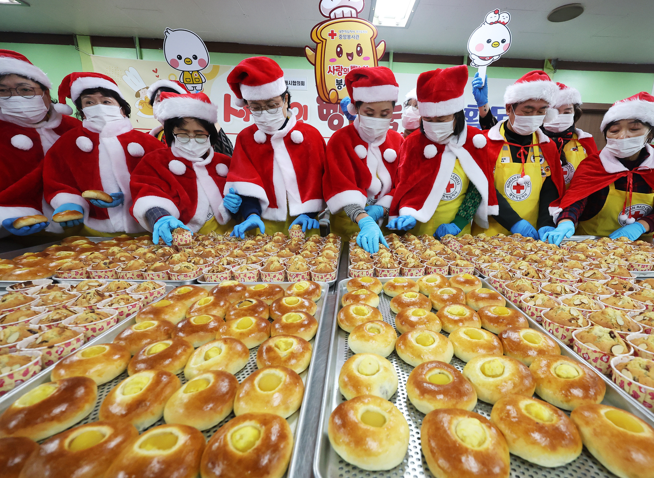 Volunteers in Santa costumes package bread at the Korean Red Cross’ branch in Anyang, Gyeonggi Province, on Wednesday. (Yonhap)