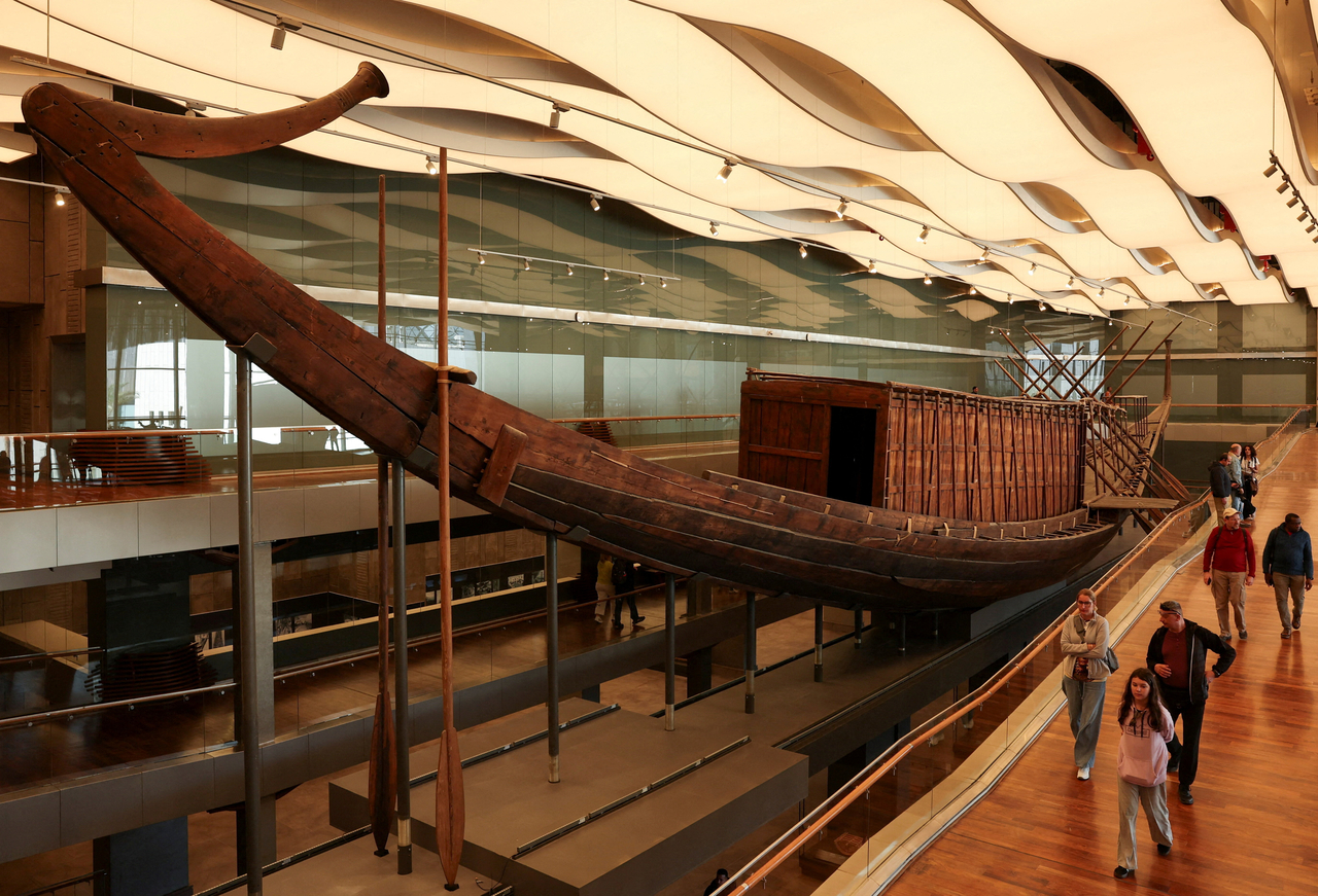 People walk next to King Khufu’s Solar Boat, at a public display at the Grand Egyptian Museum, in Giza, Egypt, Tuesday.   (Reuters-Yonhap)