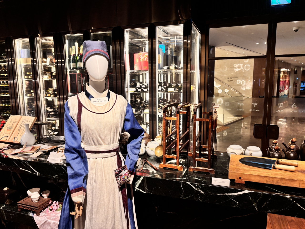 1955 Groceria displays costumes worn by the daeryeong suksu (royal master chef) alongside cooking props from the show. (Hong Yoo/The Korea Herald)