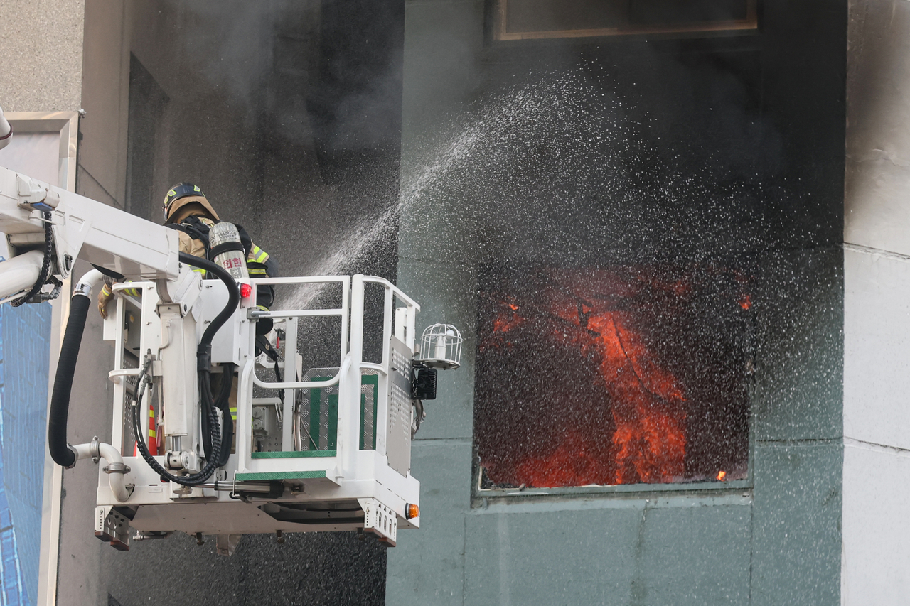 25일 오후 서울 중구 충무로역 인근 건물에서 화재가 발생했다. 소방대원이 진화 작업을 하고 있다. [연합]
