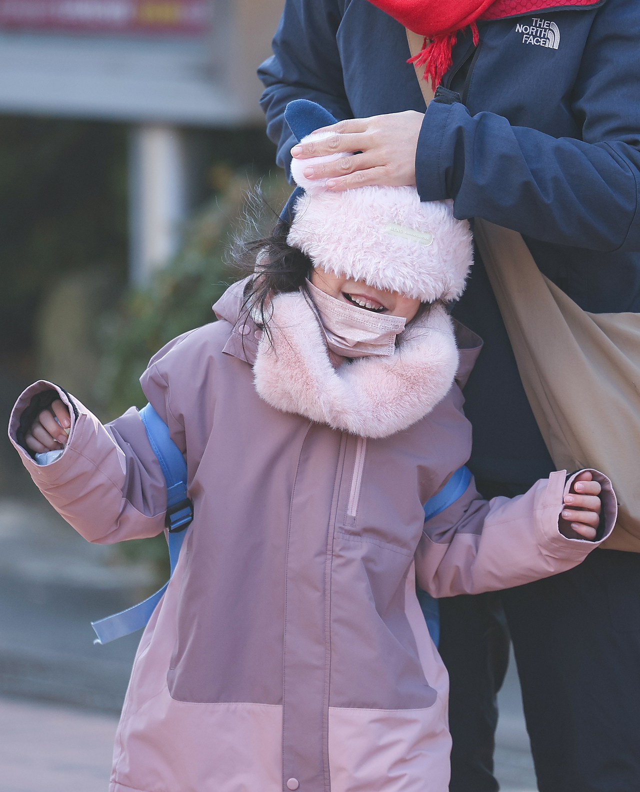 A mother ensures her child is warm amid freezing temperatures in Daegu. (Yonhap)