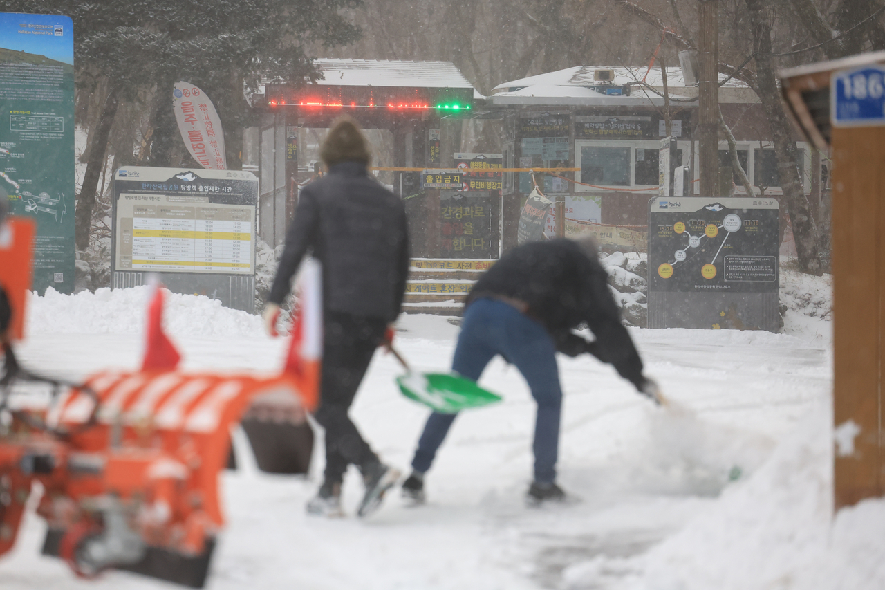 Officials clear snow at the Seongpanak Visitor Center in Hallasan National Park on Jeju Island on Friday. (Yonhap)