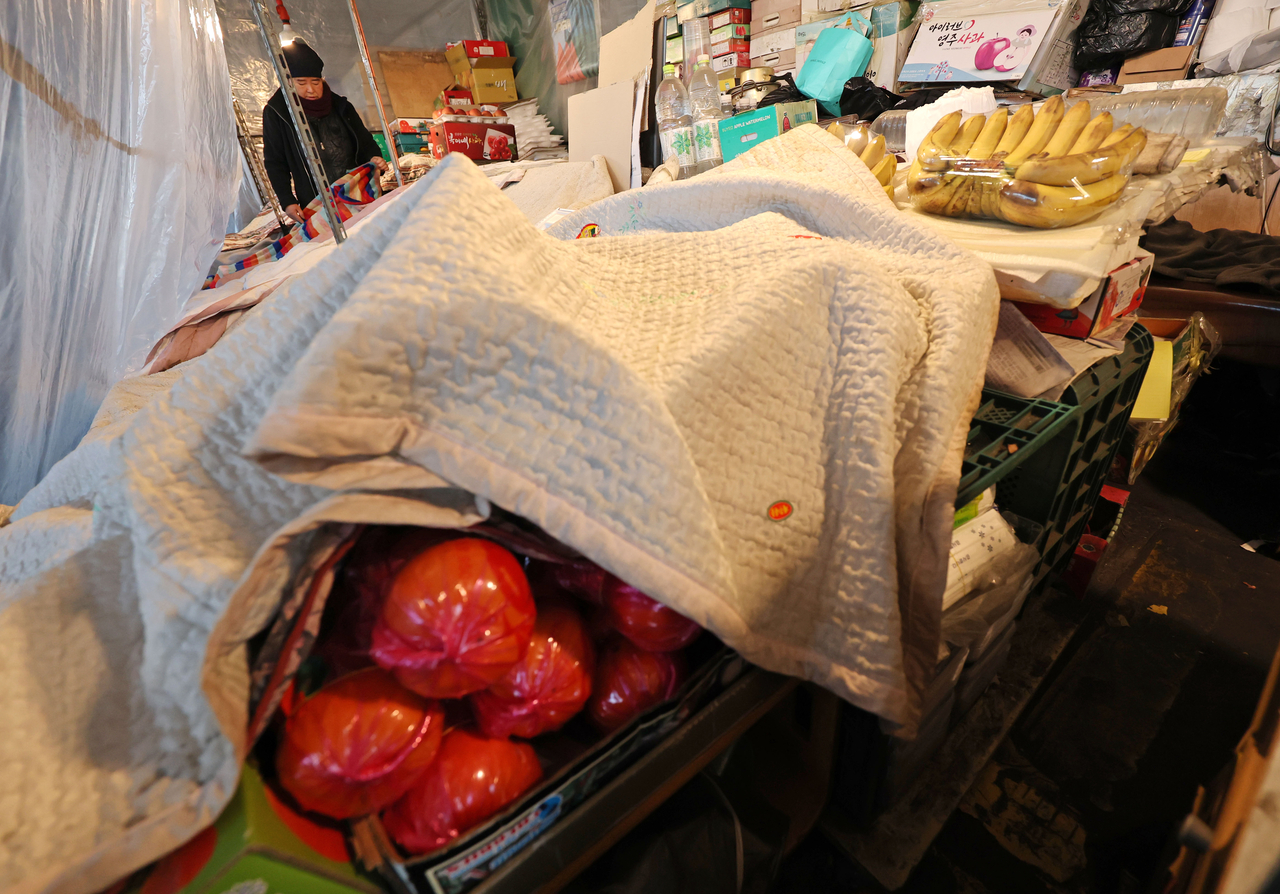 Fruit is covered with a blanket at a stall at the Garak Agricultural and Marine Products Wholesale Market in Songpa-gu, Seoul, on Friday. (Yonhap)