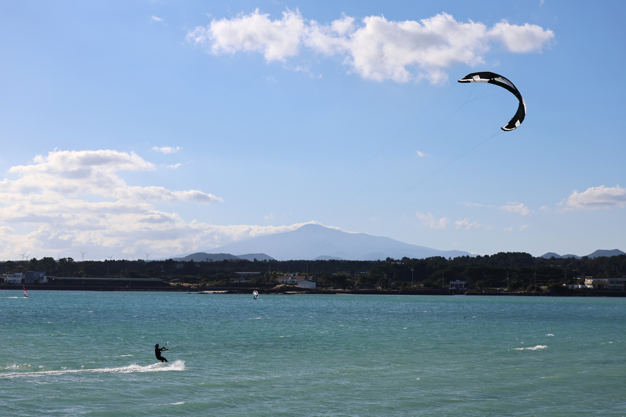 A kite surfer rides the waves at a beach on Jeju Island on Nov. 30. (Yonhap)