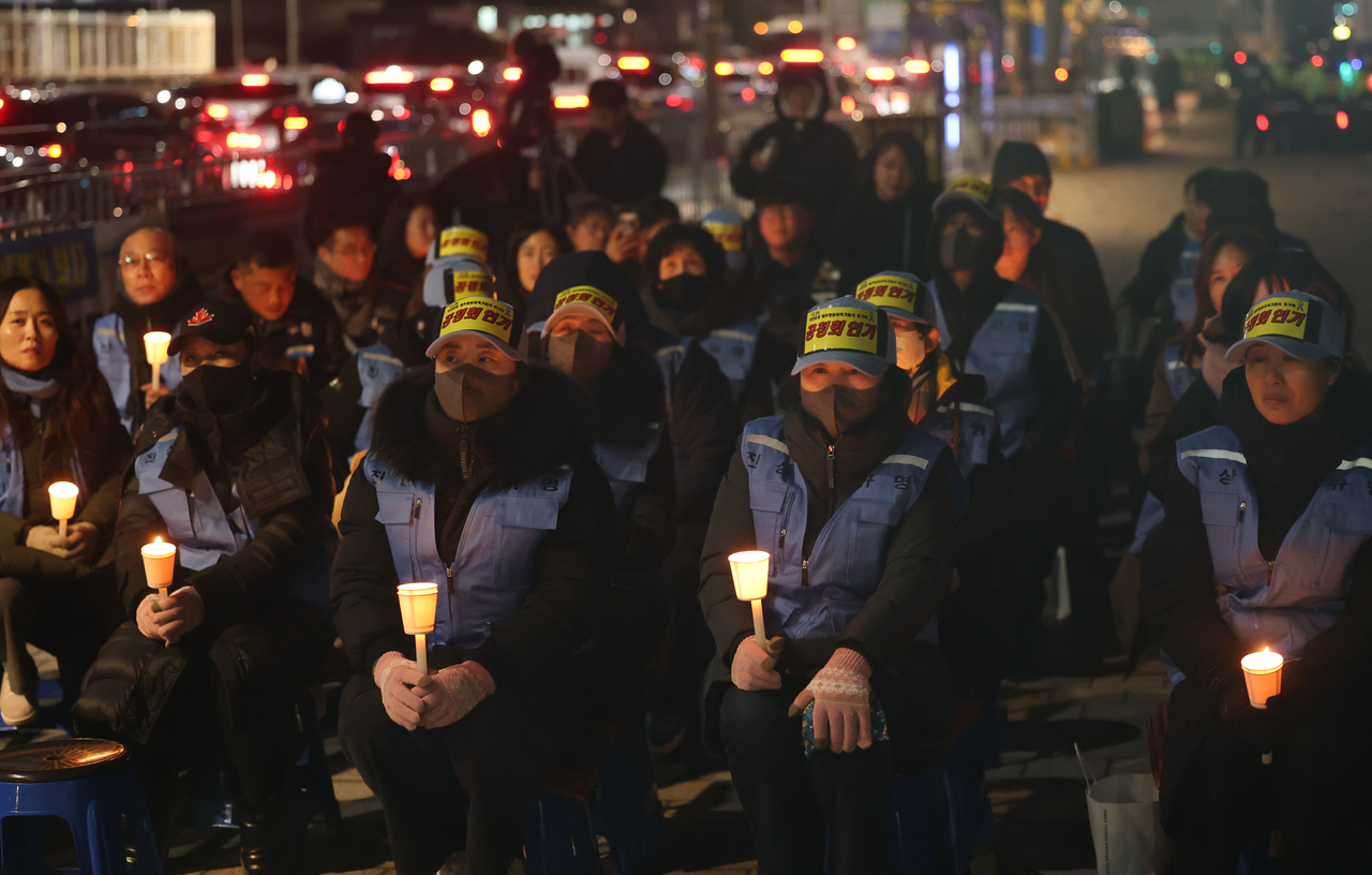 Unionized bereaved families of the Jeju Air plane crash in December 2024 hold a candlelight vigil in front of the presidential office in central Seoul on Dec. 1, calling for transparent truth-finding. (Yonhap)