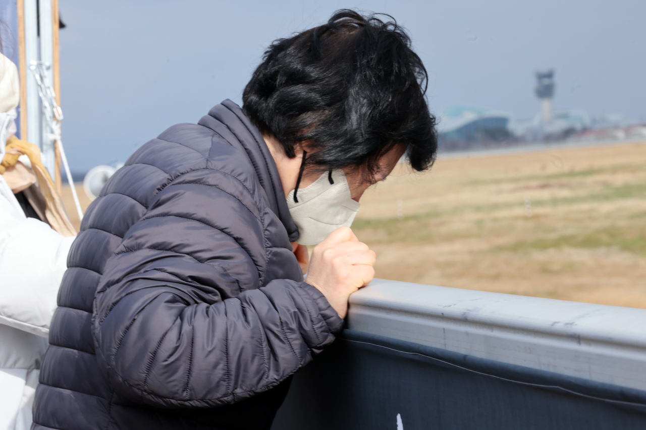 A bereaved family member of the Jeju Air plane crash mourns at Muan International Airport in South Jeolla Province on Wednesday. (Yonhap)