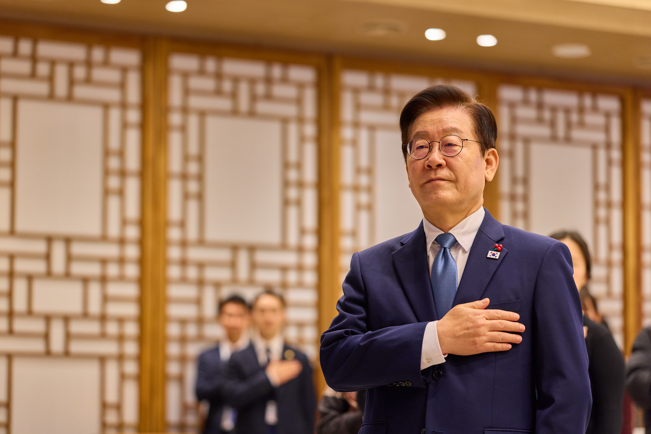 President Lee Jae Myung salutes the national flag during his meeting with families of fallen officers held at the presidential office in Seoul's Yongsan district on Friday, in this photo provided by Lee's office. (Yonhap)