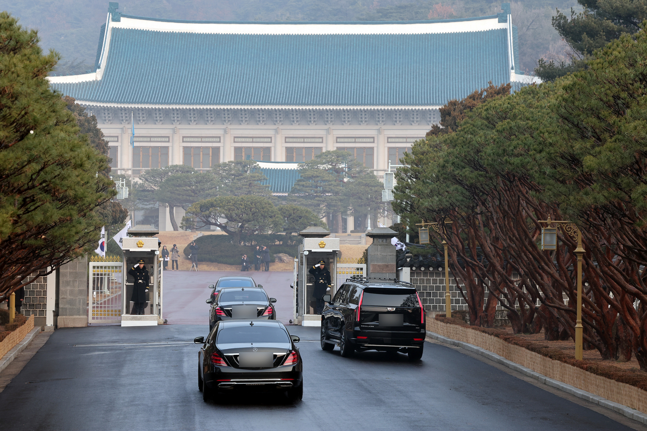 President Lee Jae Myung's motorcade passes a main gate of Cheong Wa Dae, against the backdrop of Cheong Wa Dae's main hall, on Monday. (Pool photo via Yonhap)