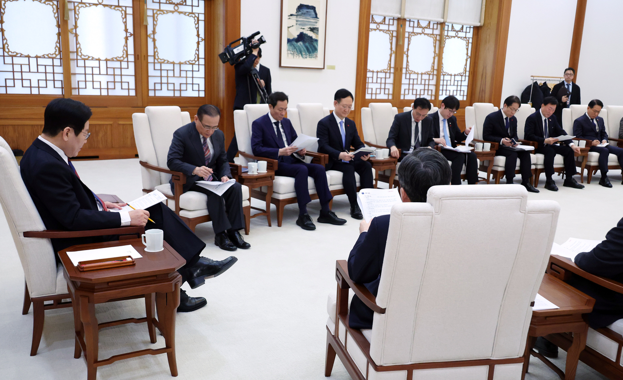 President Lee Jae Myung (right) holds a meeting over tea with his aides at Cheong Wa Dae's main hall on Monday. (Yonhap)