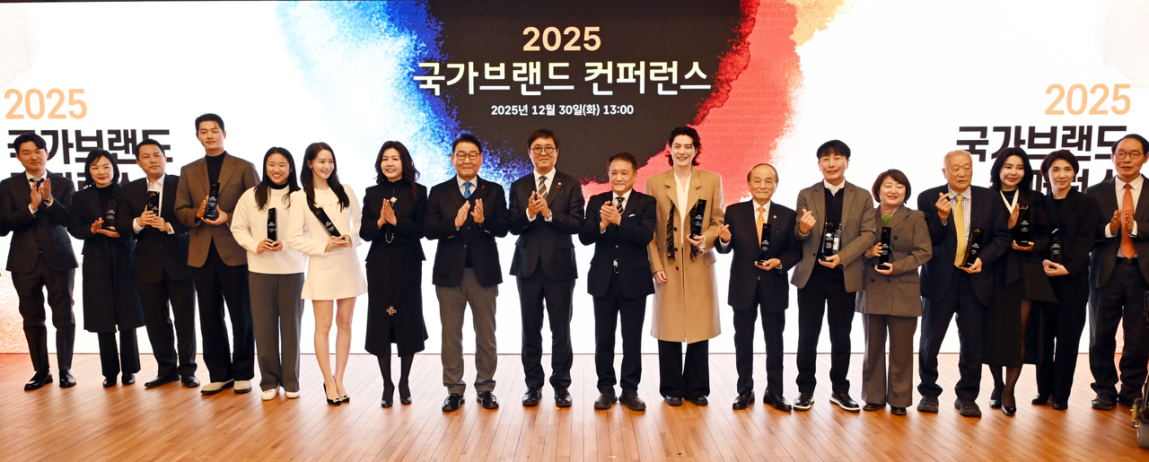 Fencing gold medalist Oh Sang-wook (fourth from left), badminton champion Ahn Se-young (fifth from left), actress and singer Lim Yoona (sixth from left), National Assembly Culture, Sports and Tourism Committee Chairman Kim Kyo-heung (eighth from left) and Culture, Sports and Tourism Minister Chae Hwi-young (ninth from left) pose with fellow honorees and participants at the 10th National Competitiveness and Nation Brand Conference at the National Assembly Library in Seoul, Tuesday. (Lee Sang-sub/The Korea Herald)