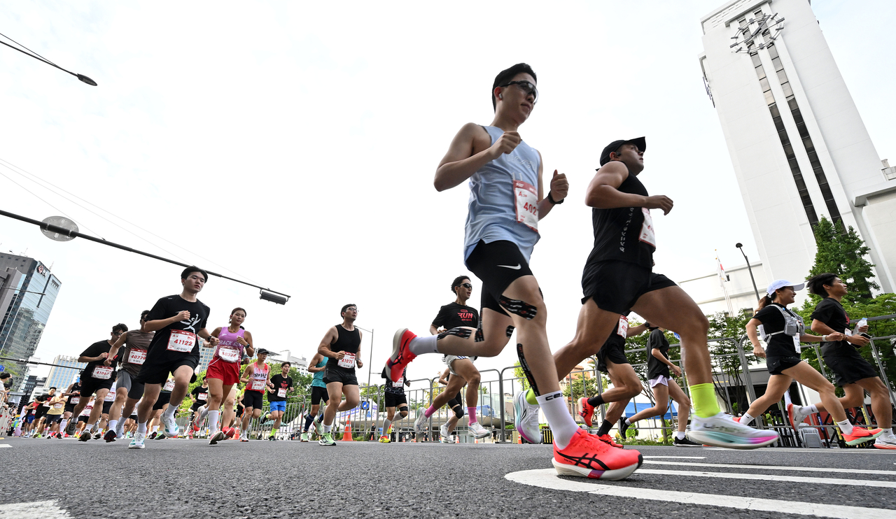 Participants in the Marvel Run 2025 Seoul event run through central Seoul on Sept. 14. (Im Se-jun/The Korea Herald)