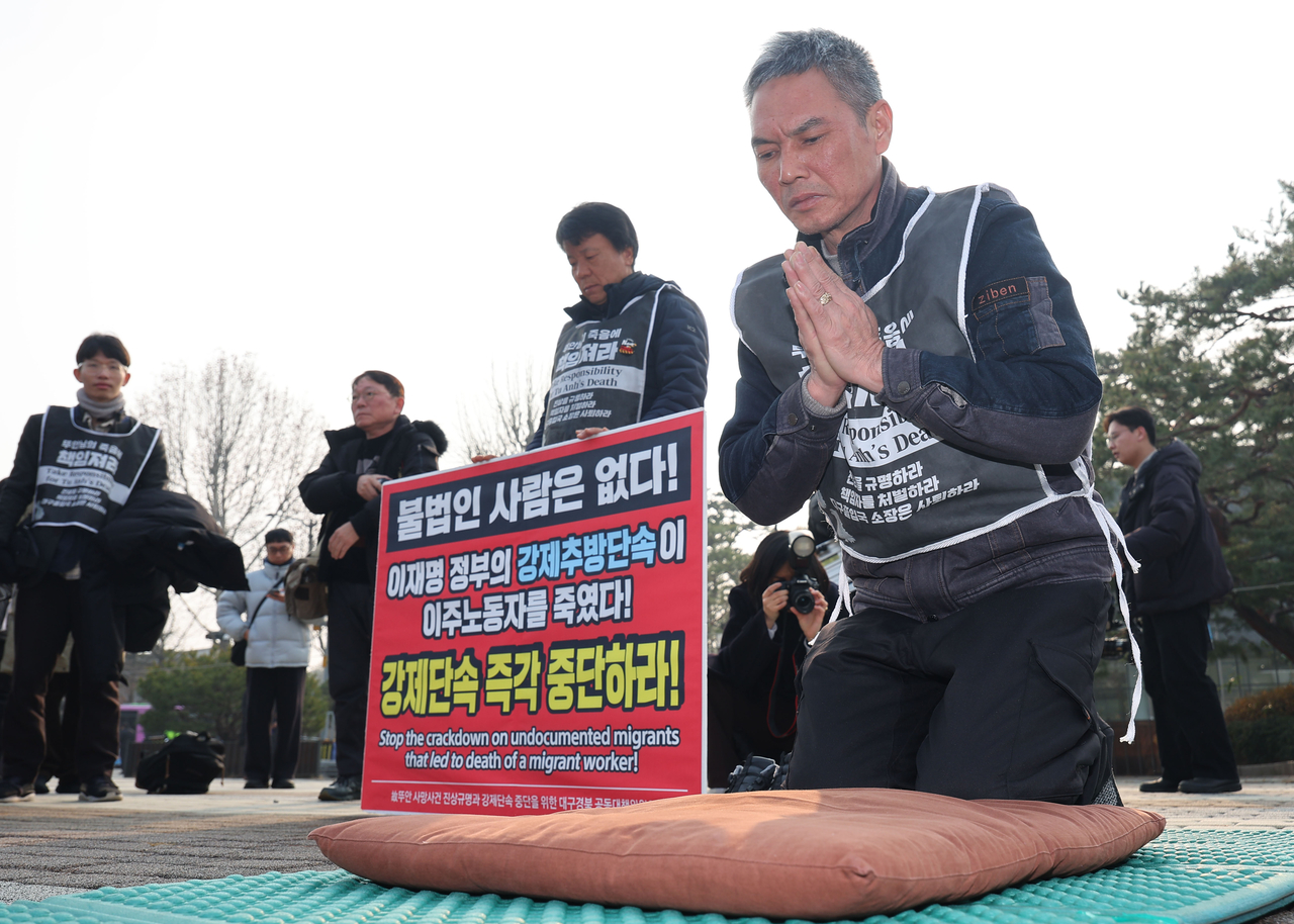 Vu Van Sung (right), father of Vu Tu Anh, a Vietnamese woman who died during an immigration enforcement raid, holds a protest calling for a halt to such immigration crackdowns in front of Cheong Wa Dae on Monday. (Yonhap)