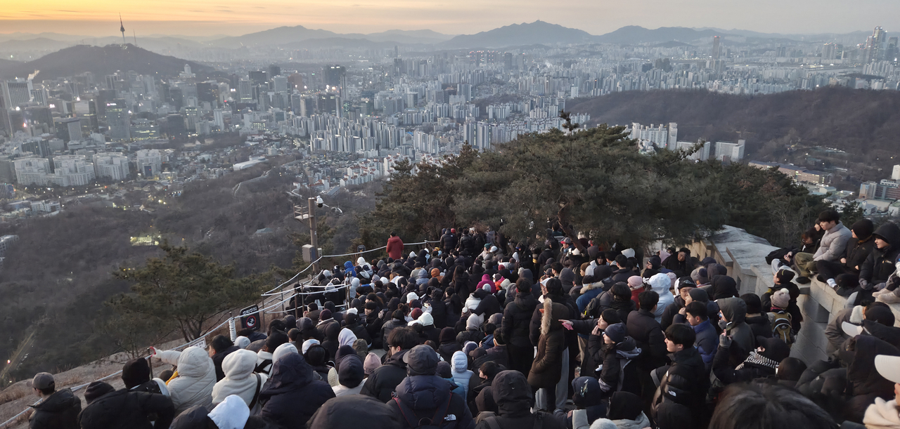 Citizens wait for the sunrise atop Inwang mountain in Seoul. (Yonhap)