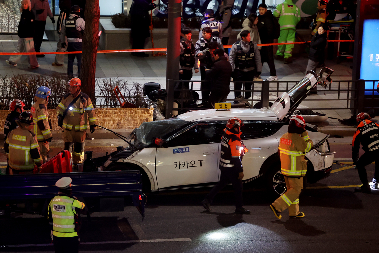 Fire and police authorities take care of the aftermath of a vehicle accident in Seoul on Friday. (Yonhap)