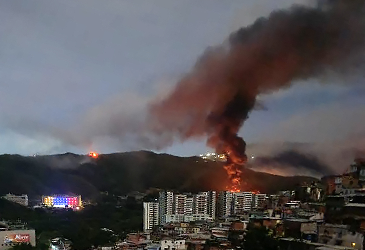 Fire at Fuerte Tiuna, Venezuela's largest military complex, is seen from a distance after a series of explosions in Caracas on Saturday. (AFP)