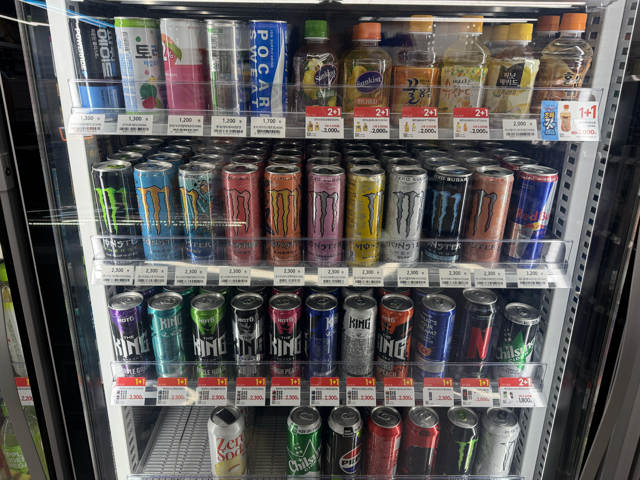 Various energy drinks are displayed on the second and third shelves of a convenience store’s beverage refrigerator. (Lee Yeon-jae/The Korea Herald)