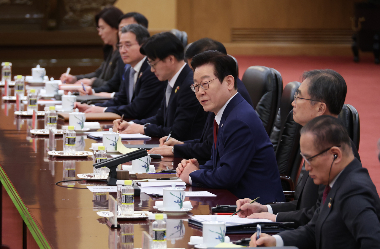 South Korean President Lee Jae Myung (third from right) speaks to Chinese President Xi Jinping during their summit talks at the Great Hall of the People in Beijing on Monday. (Yonhap)