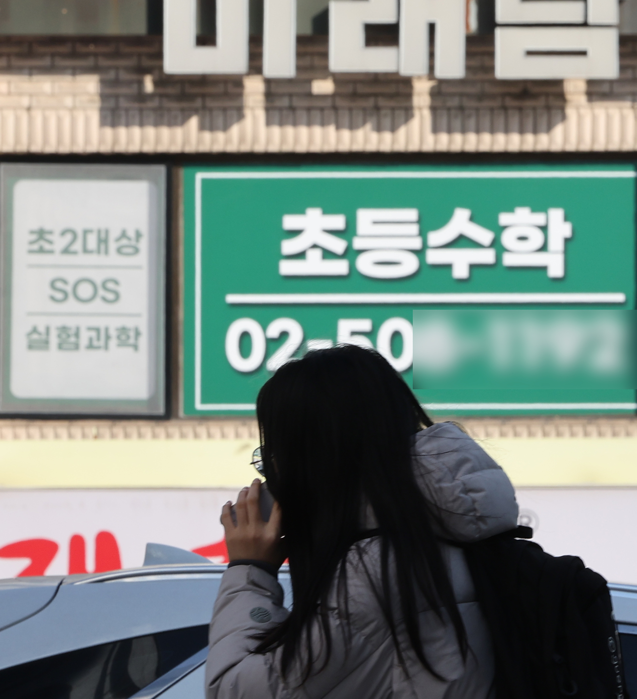 A student walks by a sign advertising a private academy for elementary school math on Sunday, in Gangnam-gu, Seoul. (Yonhap)