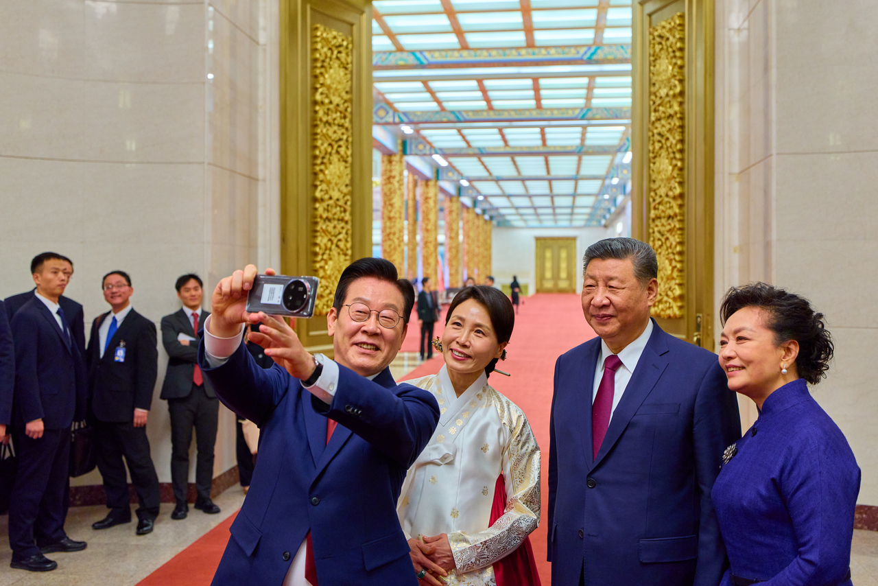 President Lee Jae Myung (left) takes a selfie with first lady Kim Hea Kyung, Chinese President Xi Jinping and his wife, Peng Liyuan, after a state dinner at the Great Hall of the People in Beijing on Monday. (Yonhap)