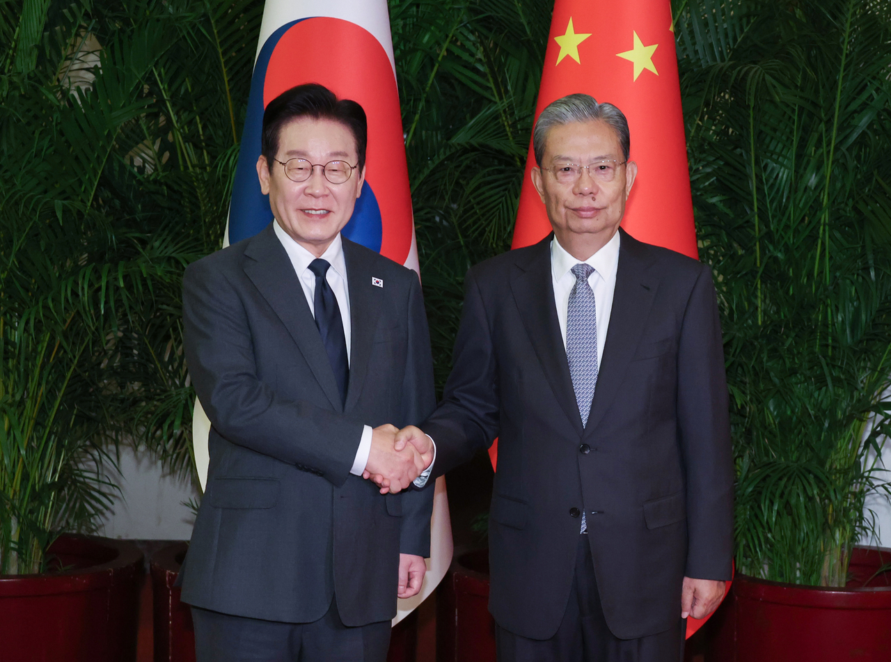 South Korean President Lee Jae Myung (left)  poses for a photo with Zhao Leji, chairperson of the Standing Committee of China's National People's Congress and ranked No. 3 in the Chinese Communist Party, during their meeting at the Great Hall of the People in Beijing on Tuesday. (Yonhap)